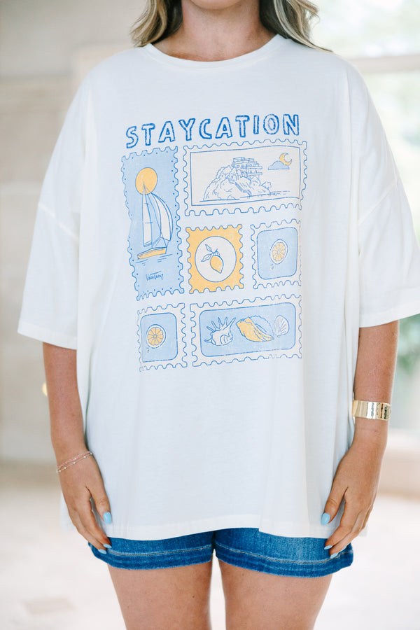 Plus Size ivory boyfriend tee with a blue and yellow staycation stamp graphic and denim shorts.