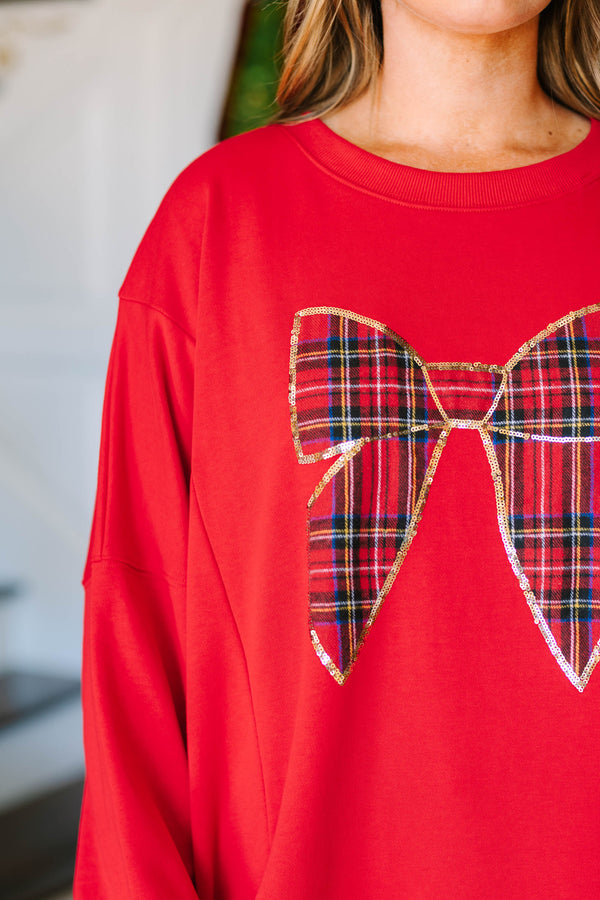 Plus Size red pullover sweatshirt with a large plaid bow graphic outlined in gold sequins.