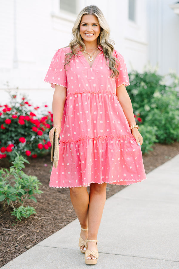 Pink tiered cotton shift dress with a split neckline, short sleeves, and white floral embroidery.