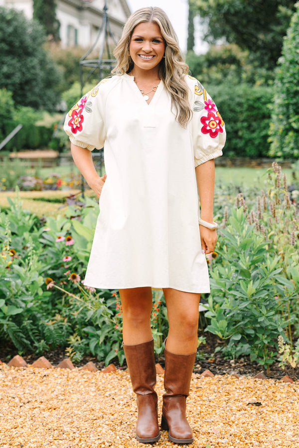 Plus Size cream cotton dress with a V-neckline and puff sleeves featuring colorful floral embroidery.