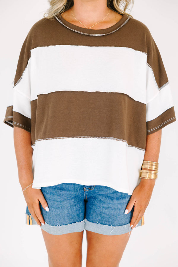 Plus Size brown and white wide-striped oversized tee with exposed seams and denim shorts.
