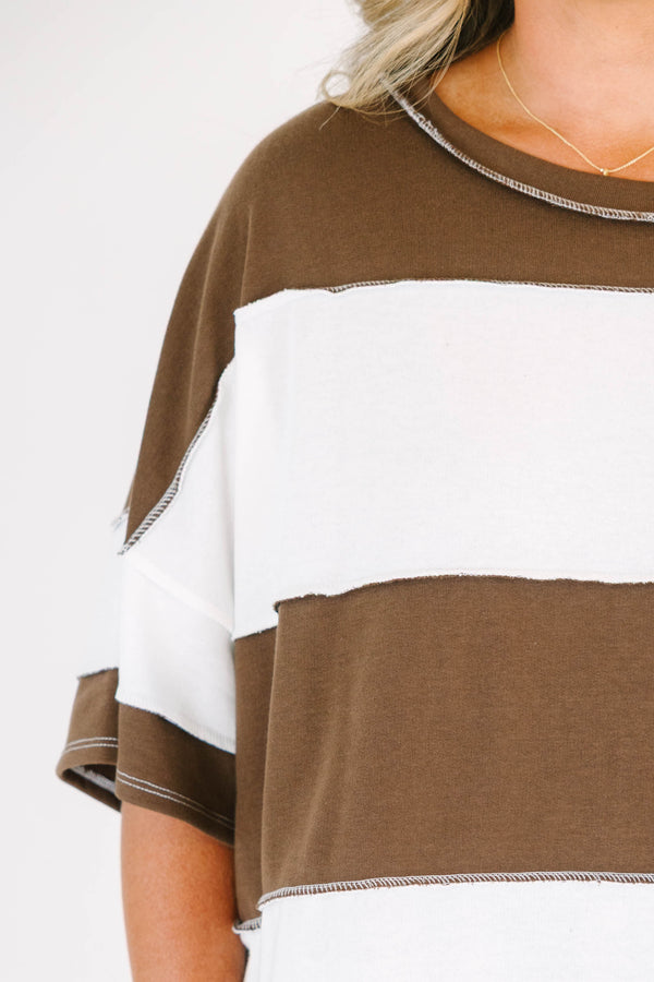 Plus Size brown and white wide-striped oversized tee with exposed seams and denim shorts.
