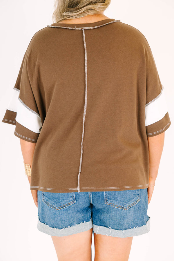 Plus Size brown and white wide-striped oversized tee with exposed seams and denim shorts.