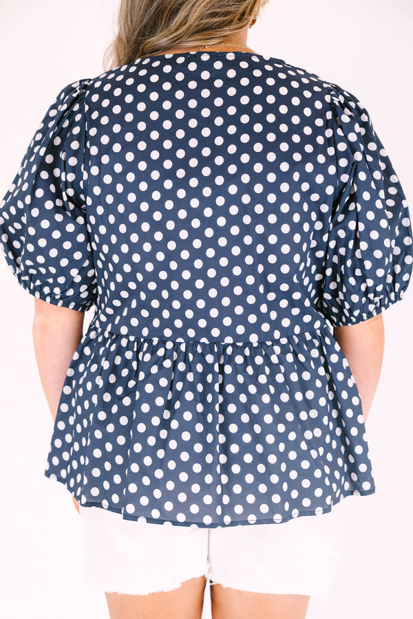 Chic soul plus size clothing, navy top with white polka dots and bubble sleeves as well as three white bows going down the center of the top 
