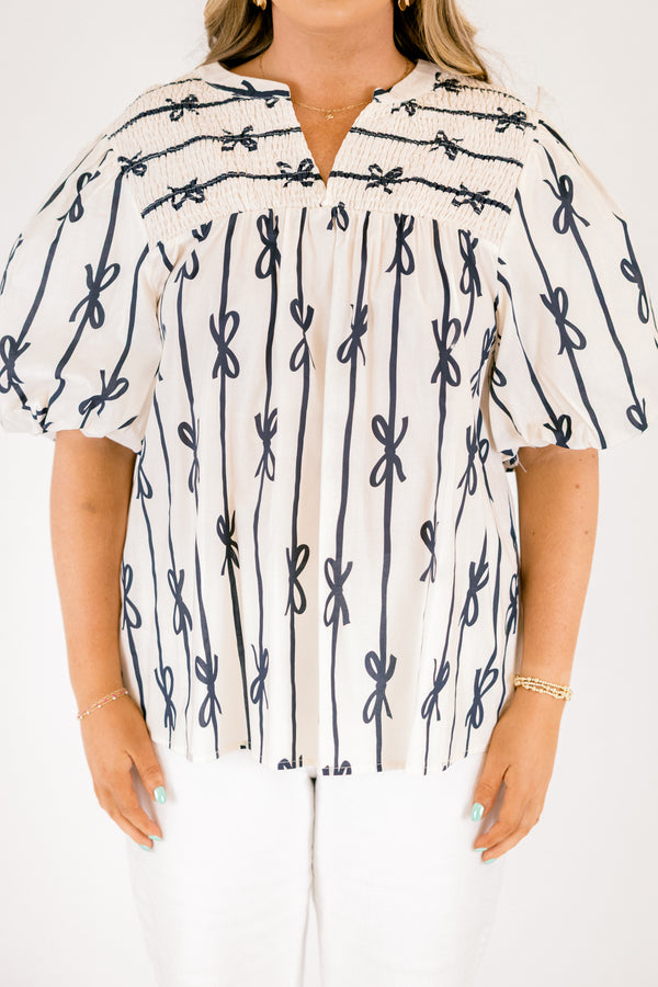 Chic Soul plus size clothing, off white short sleeve top with vertical navy blue lines and bows on the top and horizontal navy blue lines and bows along the top with a v-neckline