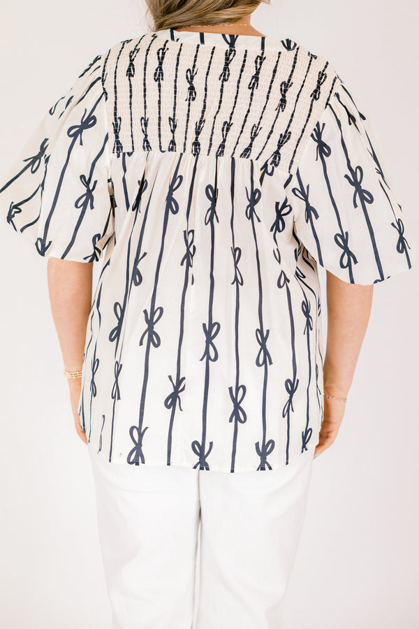 Chic Soul plus size clothing, off white short sleeve top with vertical navy blue lines and bows on the top and horizontal navy blue lines and bows along the top with a v-neckline