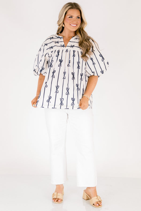 Chic Soul plus size clothing, off white short sleeve top with vertical navy blue lines and bows on the top and horizontal navy blue lines and bows along the top with a v-neckline