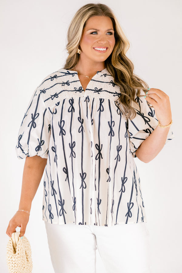 Chic Soul plus size clothing, off white short sleeve top with vertical navy blue lines and bows on the top and horizontal navy blue lines and bows along the top with a v-neckline