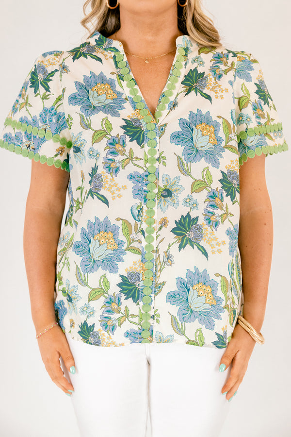 Chic Soul plus size clothing, white short sleeve top with blue and green tropical floral pattern and green dot embroidery along the hems of the sleeves and bordering the v-neckline going down the middle of the top