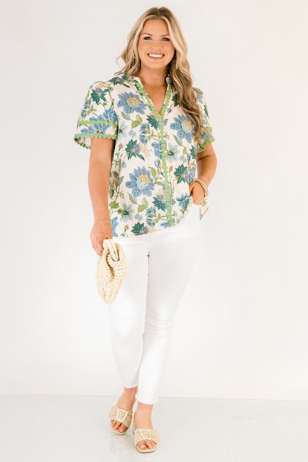 Chic Soul plus size clothing, white short sleeve top with blue and green tropical floral pattern and green dot embroidery along the hems of the sleeves and bordering the v-neckline going down the middle of the top