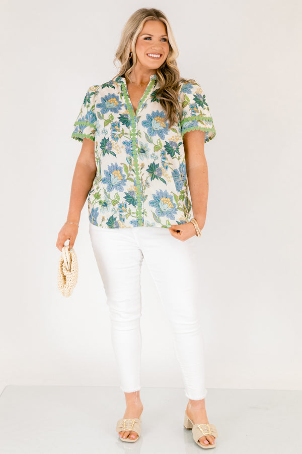 Chic Soul plus size clothing, white short sleeve top with blue and green tropical floral pattern and green dot embroidery along the hems of the sleeves and bordering the v-neckline going down the middle of the top