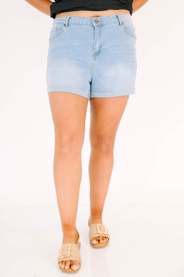Plus size light wash denim shorts with a high-waisted fit, cuffed hem, and stretchy fabric.