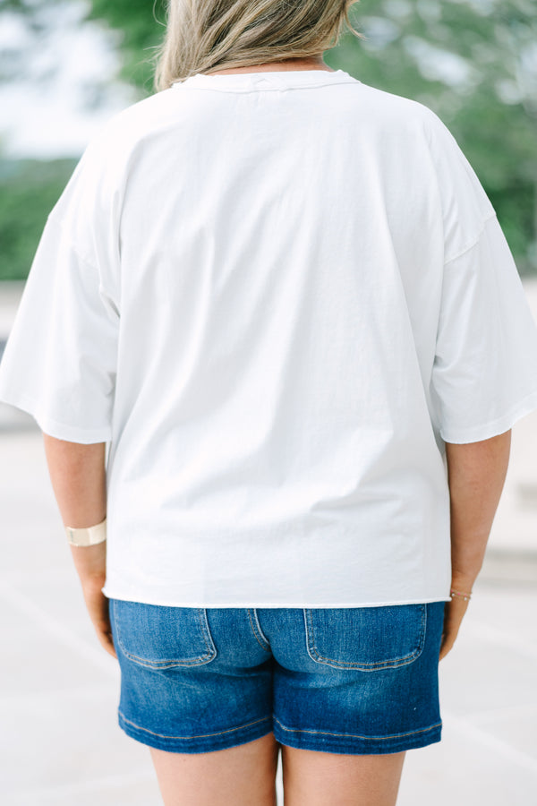 Back view of a white vintage wash  with a distressed USA flag graphic, raw-edge sleeves, and an unfinished hem.