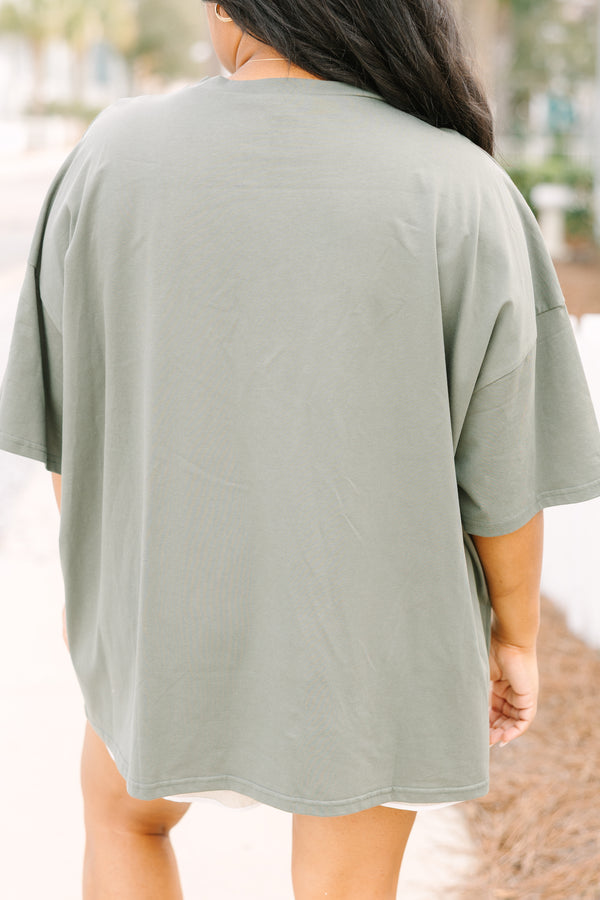 Chic Soul plus size clothing, moss green short sleeve oversized boyfriend tee with “USA” in bold block white font with star cutouts 
