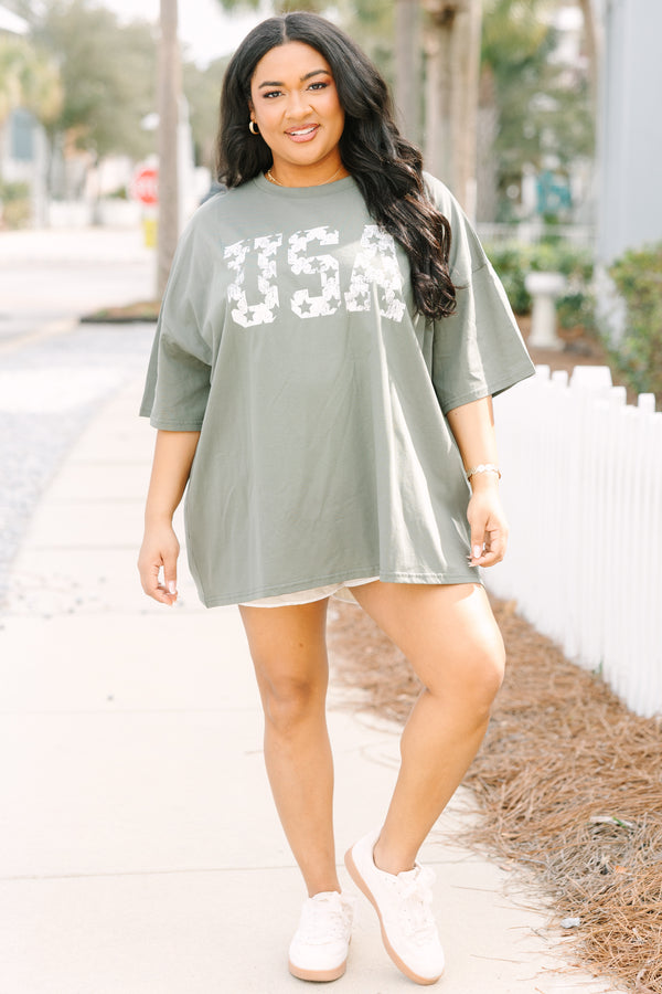 Chic Soul plus size clothing, moss green short sleeve oversized boyfriend tee with “USA” in bold block white font with star cutouts 
