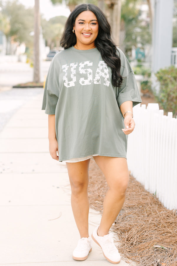 Chic Soul plus size clothing, moss green short sleeve oversized boyfriend tee with “USA” in bold block white font with star cutouts 
