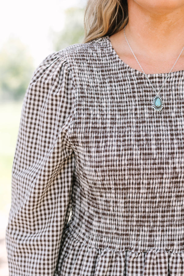 Plus Size brown gingham top with a smocked bodice, long sleeves, and a peplum hem.