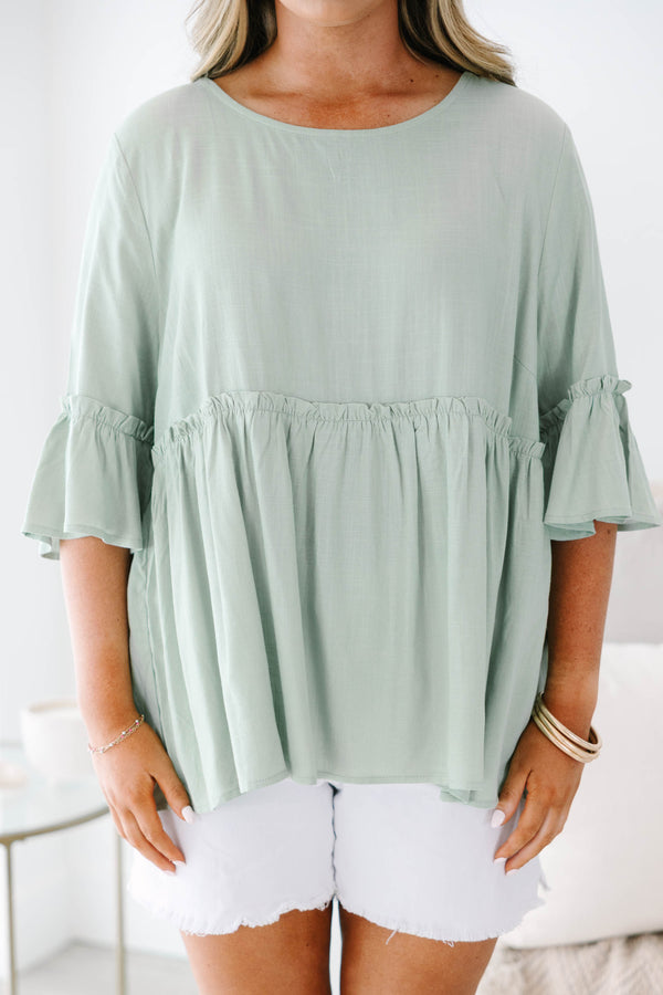 Plus Size sage green babydoll top with elbow-length ruffle sleeves and a round neckline.