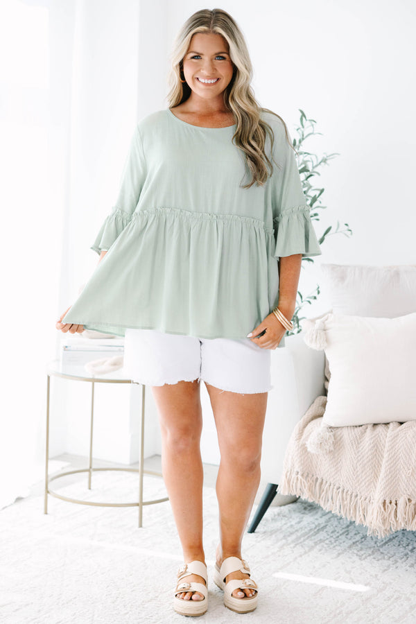 Plus Size sage green babydoll top with elbow-length ruffle sleeves and a round neckline.